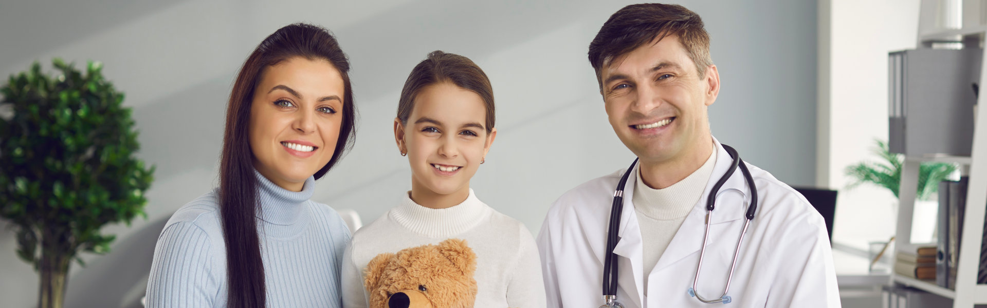 doctor with woman and a kid looking at the camera