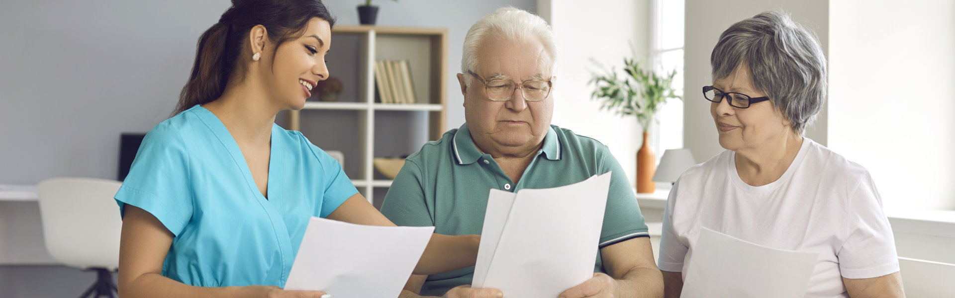 nurse with elderly couple holding folder